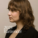 Kvinna med halvlångt mjukt vågigt hår i profil, bild till Green Heads guide om hårtrender 2025 med fokus på lob, naturliga färger och volym.