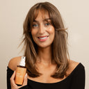 Kvinna med långt brunt hår visar upp Green Heads Heat Defence