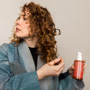 Kvinnar stylar håret med Green Heads Curl Cream